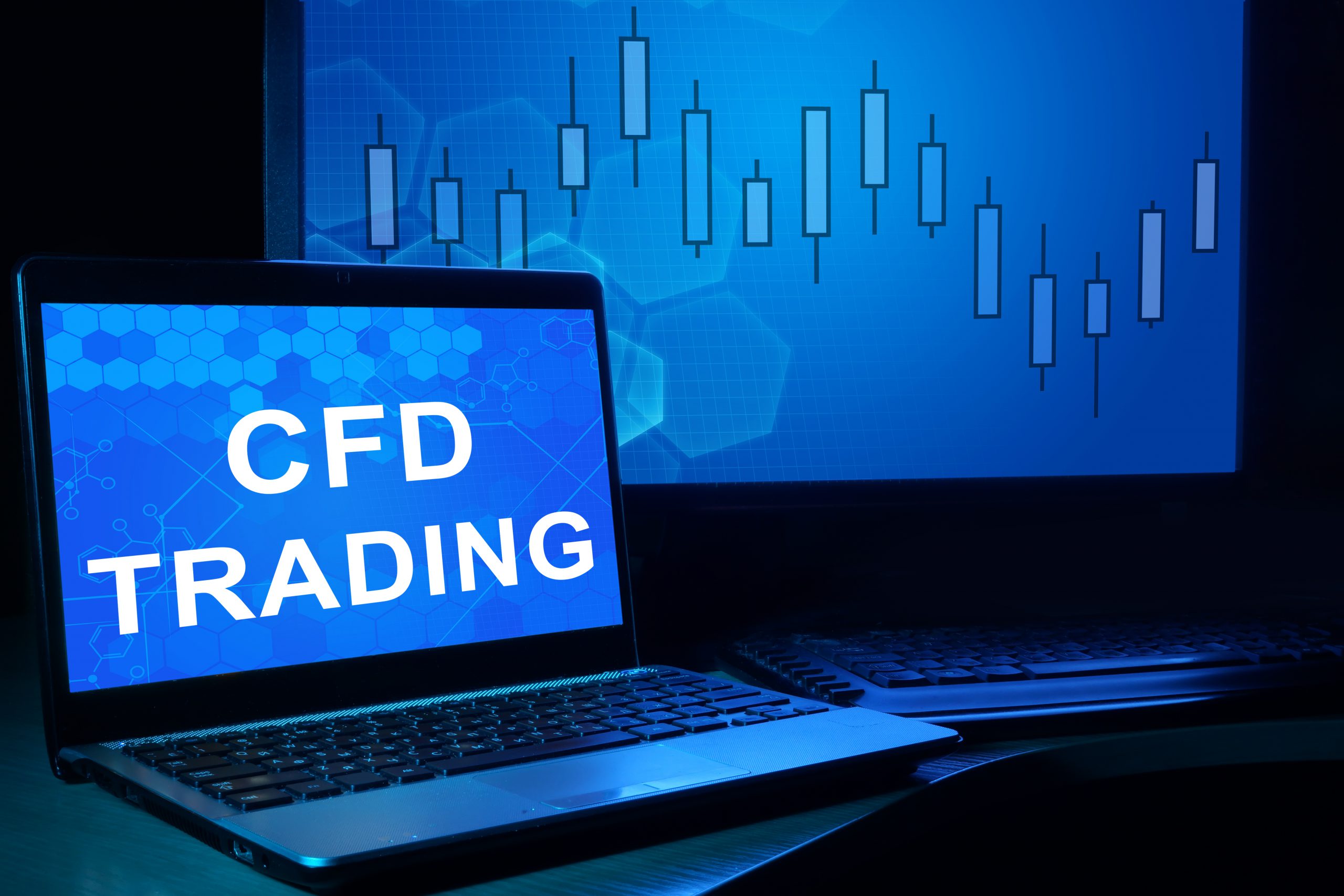 Dwa ekrany - jeden z napisem CFD trading, drugi z wykresem kursu